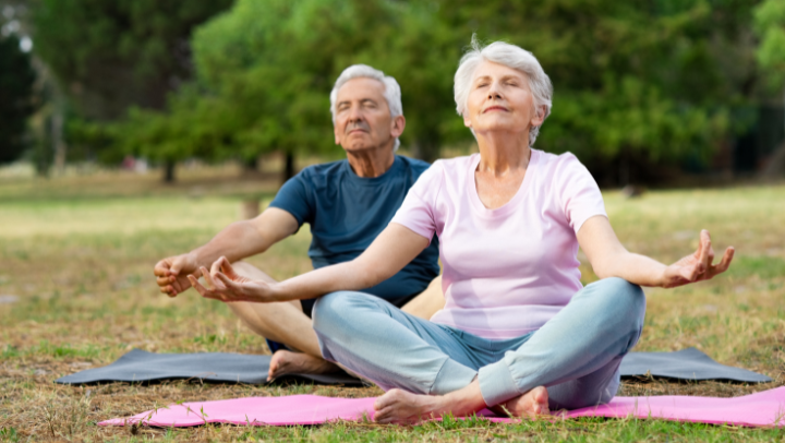 an elderly couple meditating